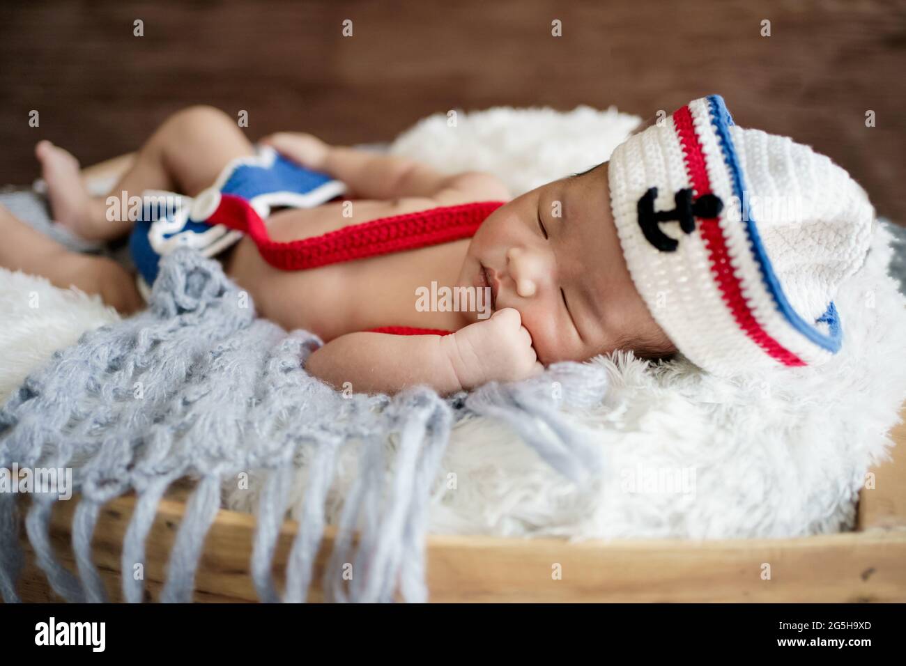 newborn baby boy wearing a white and blue sailor hat Stock Photo Alamy