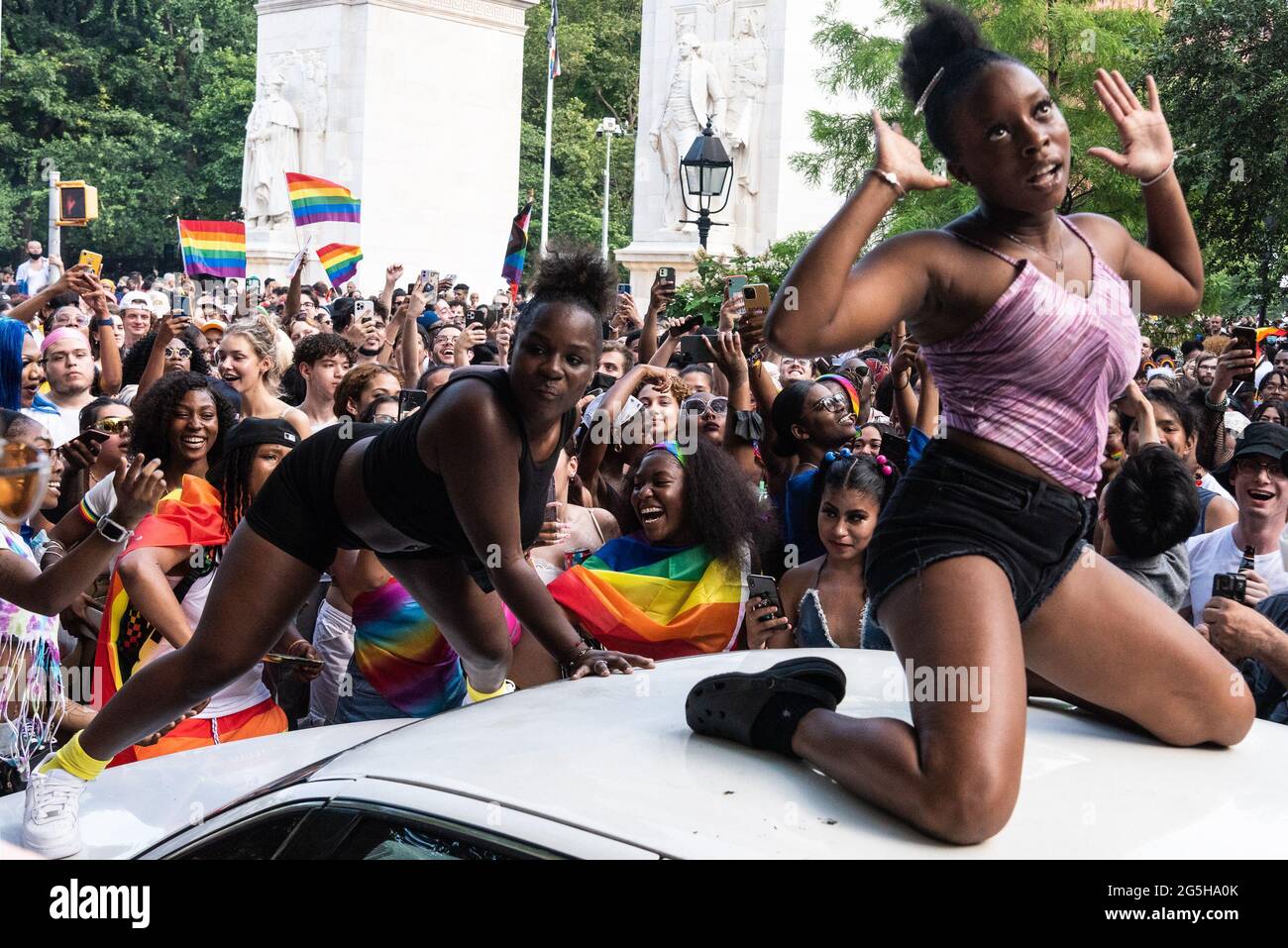 Two young people dance on a car as thousands of New Yorkers celebrated Gay Pride in the Village in New York City on June 27, 2021. With many New Yorkers vaccinated and most COVID-19 restrictions lifted, locals and out-of-towners joined the party, even though the traditional Pride Parade was held virtually for the second time. (Photo by Gabriele Holtermann/Sipa USA) Credit: Sipa USA/Alamy Live News Stock Photo
