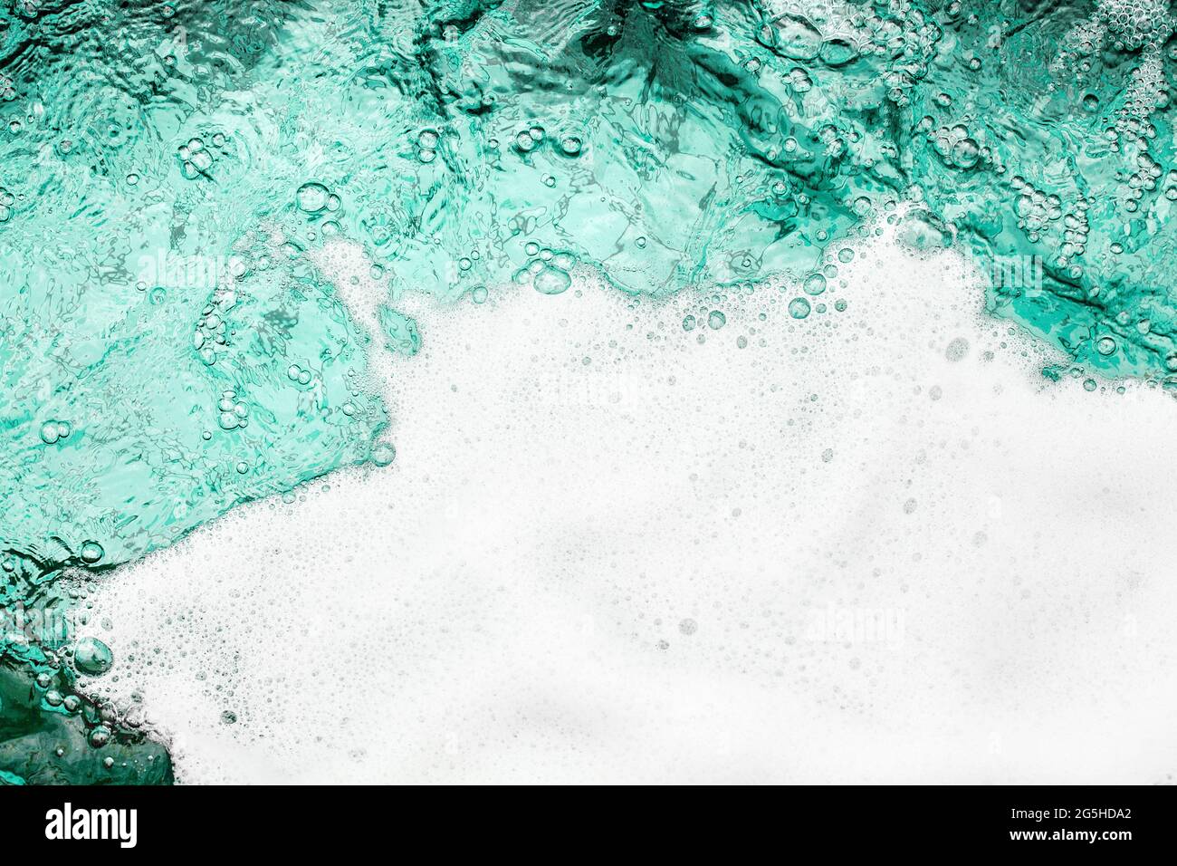 Blue sea water white foam texture background closeup, foamy ocean wave