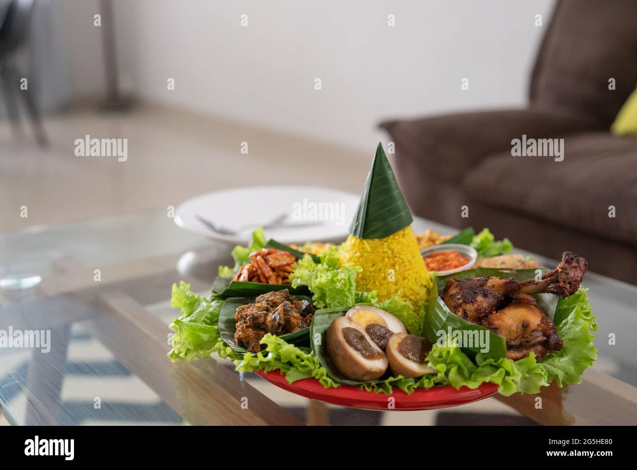 nasi tumpeng. indonesian cuisine yellow rice on banana leaf Stock Photo ...