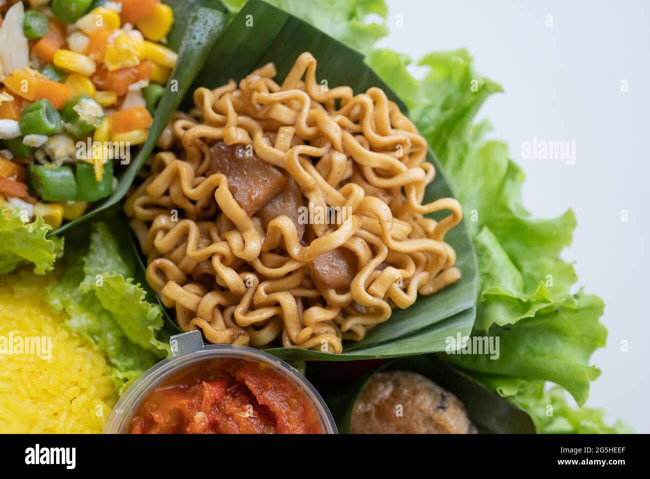 nasi tumpeng. indonesian cuisine yellow rice on banana leaf Stock Photo ...