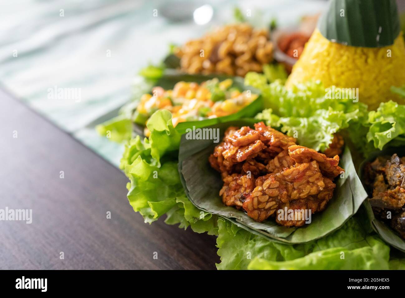 nasi tumpeng. indonesian cuisine yellow rice on banana leaf Stock Photo ...