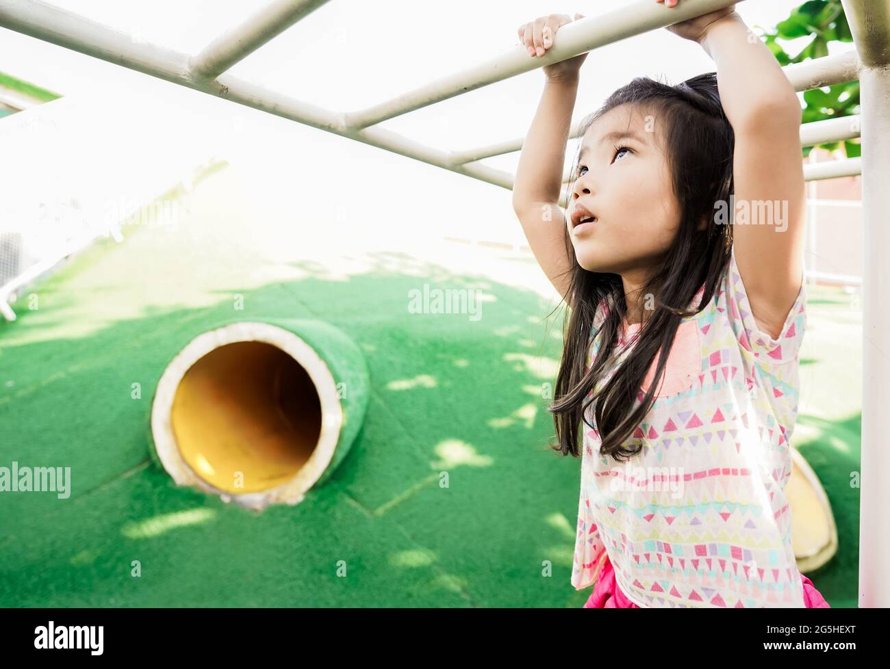 healthy girl hanging on a bar in the playground Stock Photo Alamy