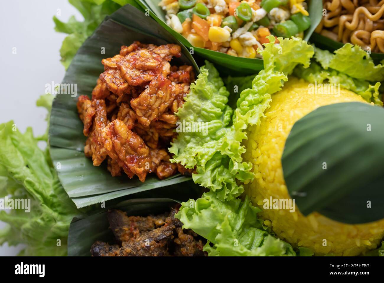 nasi tumpeng. indonesian cuisine yellow rice on banana leaf Stock Photo