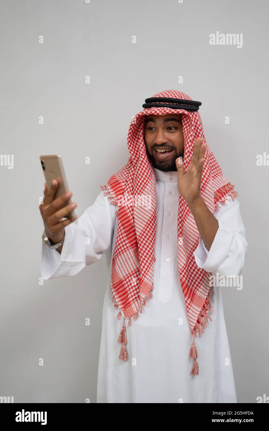 an arabian youth in a turban makes a video call using a mobile phone while  smiling with a hand gesture Stock Photo - Alamy