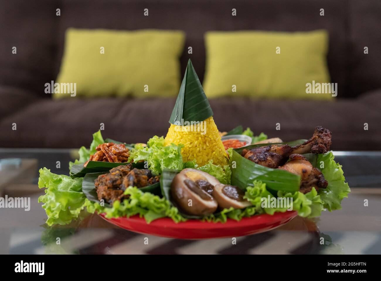nasi tumpeng. indonesian cuisine yellow rice on banana leaf Stock Photo ...