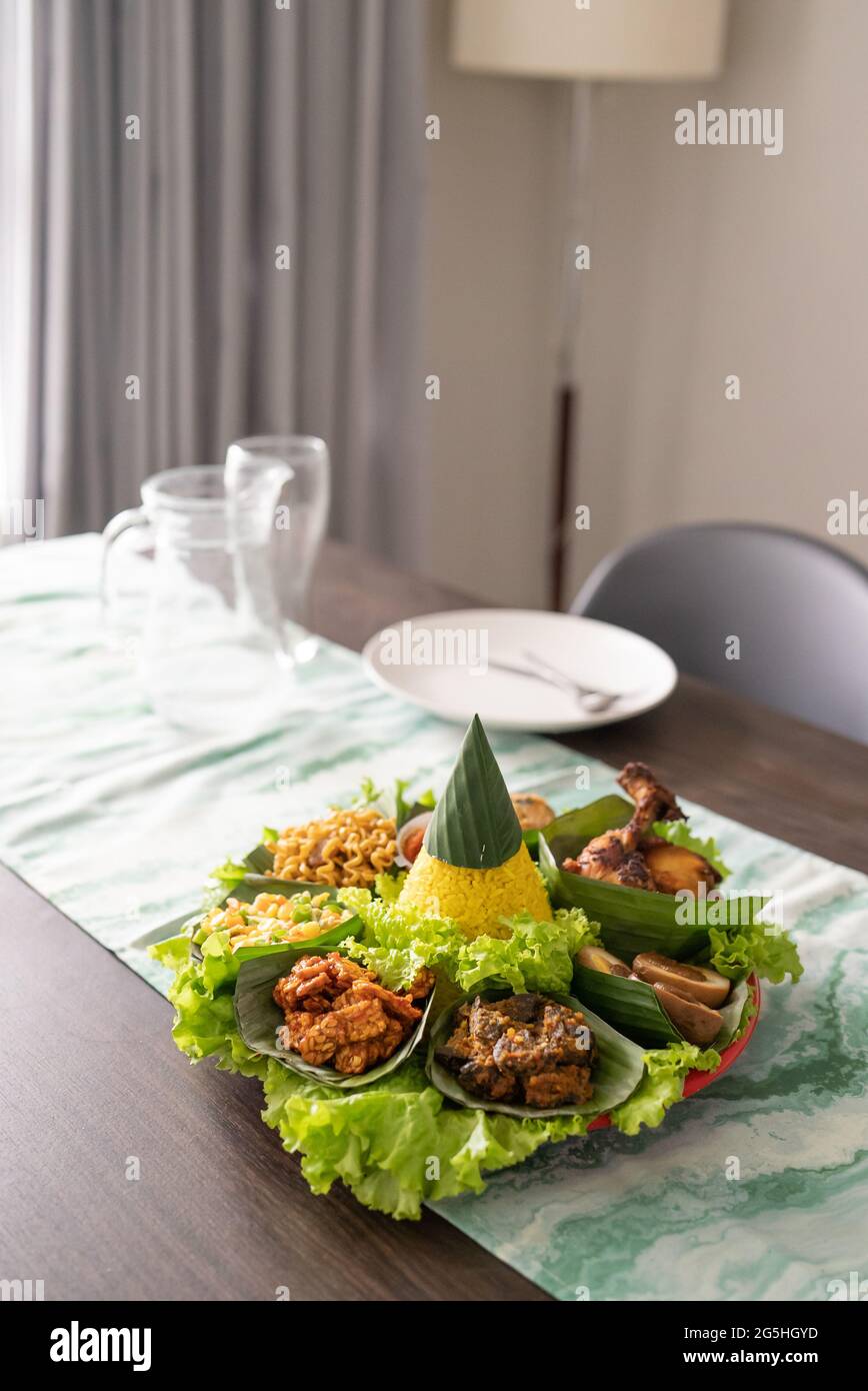 nasi tumpeng. indonesian cuisine yellow rice on banana leaf Stock Photo ...