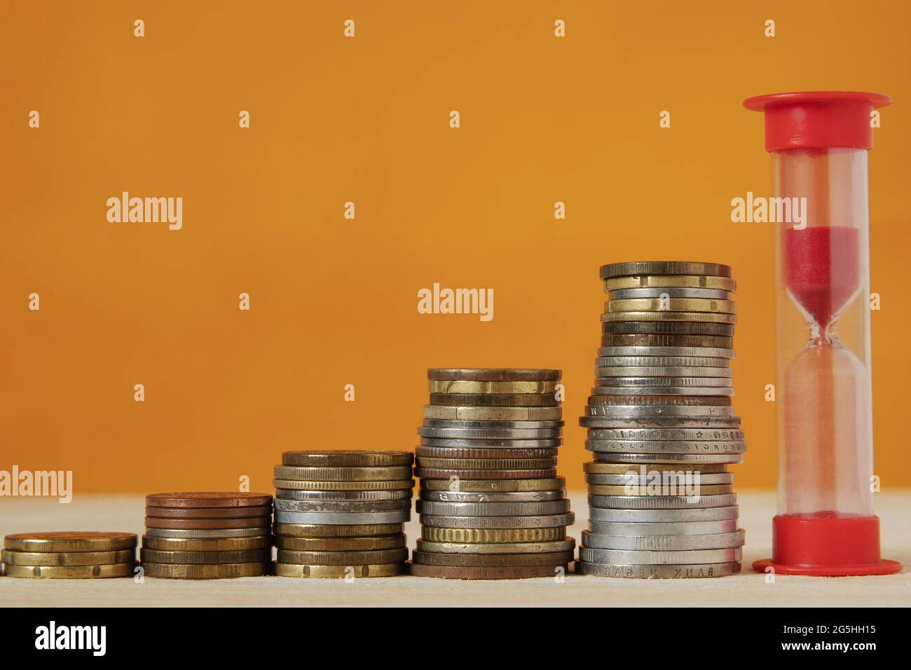 The pyramid of stacks of coins goes up, with an hourglass at the head ...