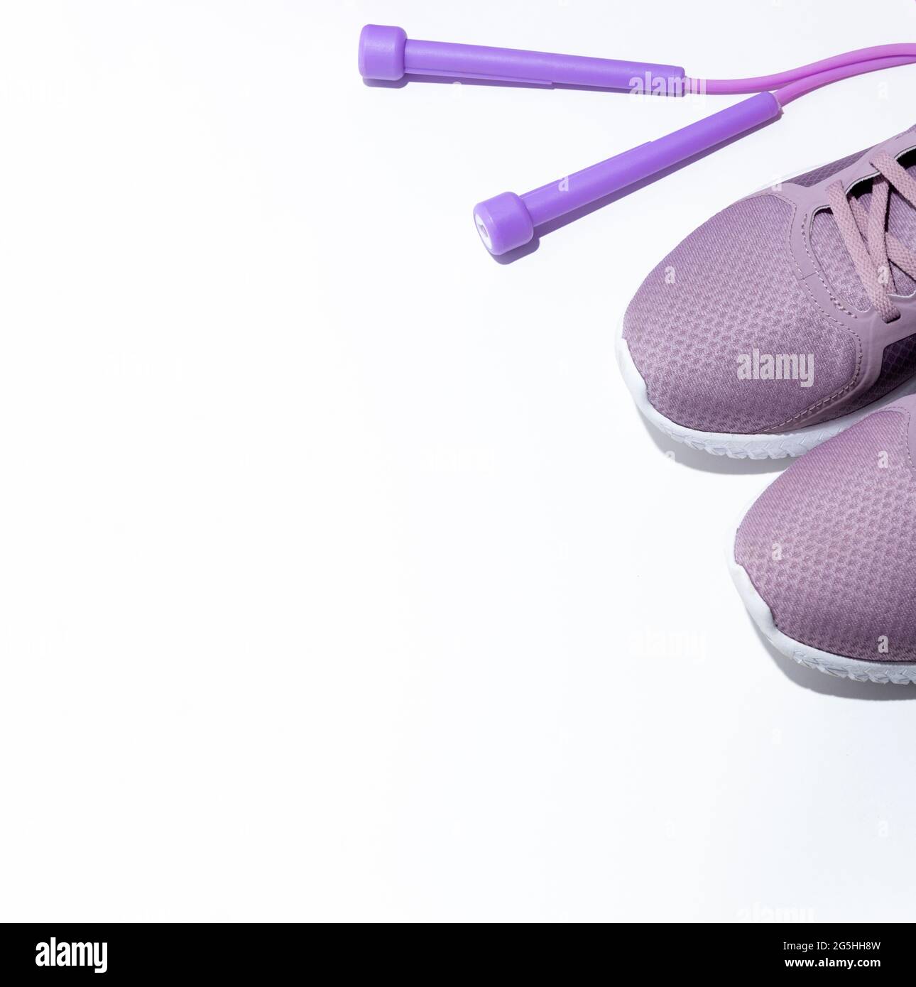 Purple jump rope, sneakers on a white background. Banner with space for  text. Side view. Selective focus Stock Photo - Alamy