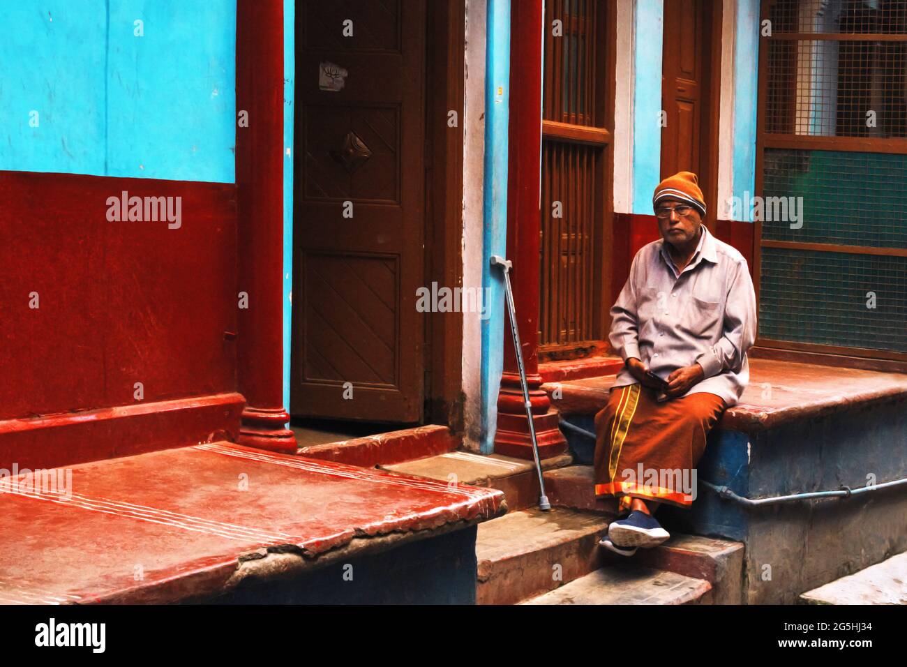 Varanasi, Banaras, Uttar Pradesh, India - February 04, 2021, Indian Old Man sitting sitting on a narrow lane of city Uttar pradesh. Stock Photo