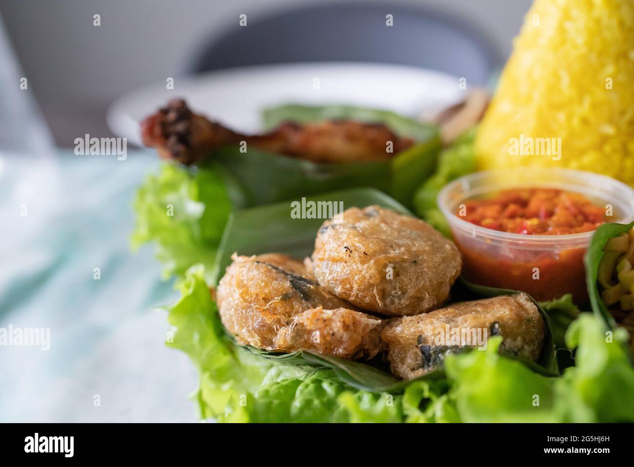 nasi tumpeng. indonesian cuisine yellow rice on banana leaf Stock Photo ...