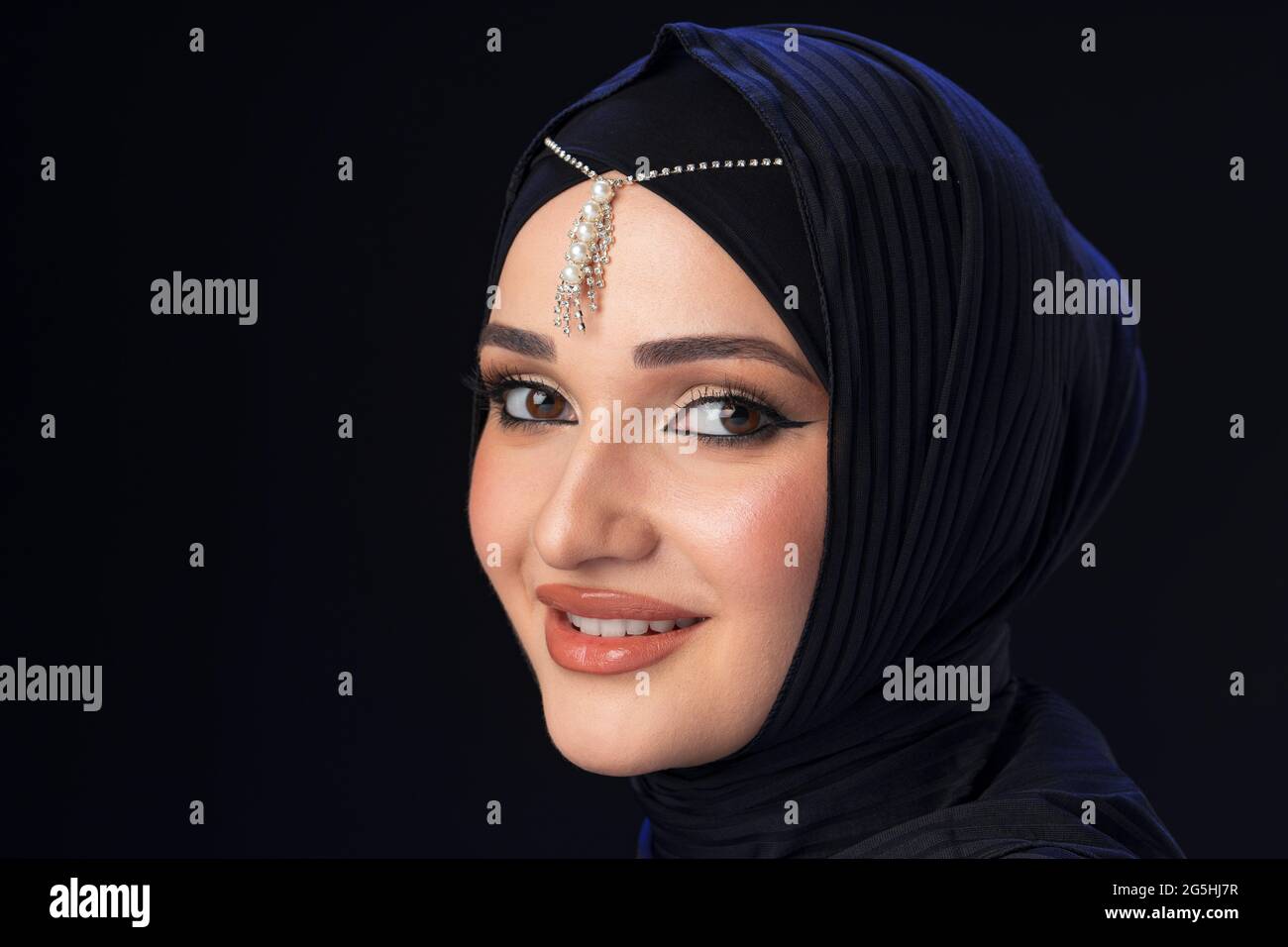Portrait of a young muslim woman in hijab on black background Stock ...