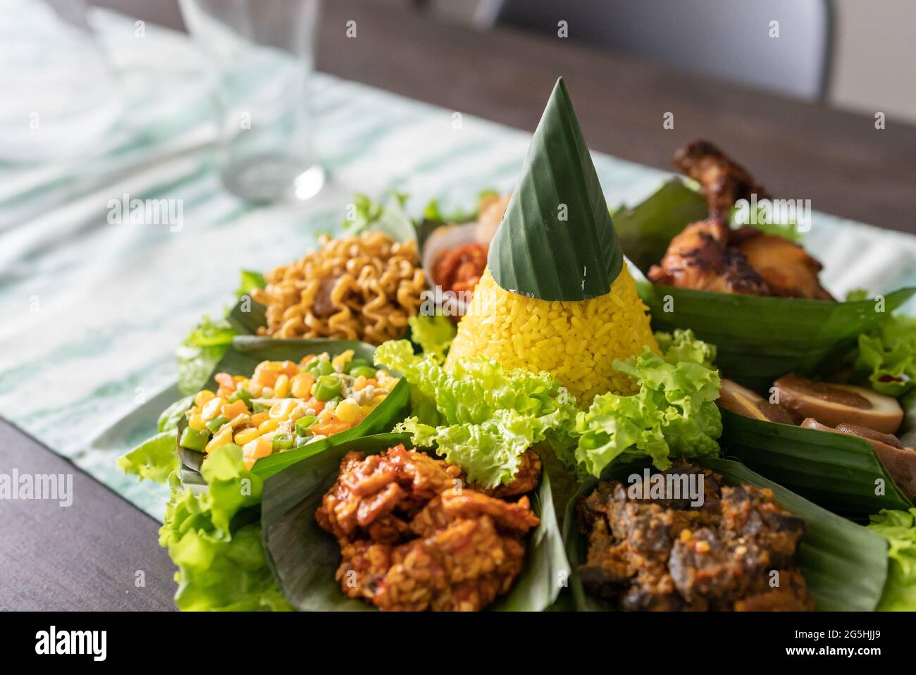 nasi tumpeng. indonesian cuisine yellow rice on banana leaf Stock Photo ...