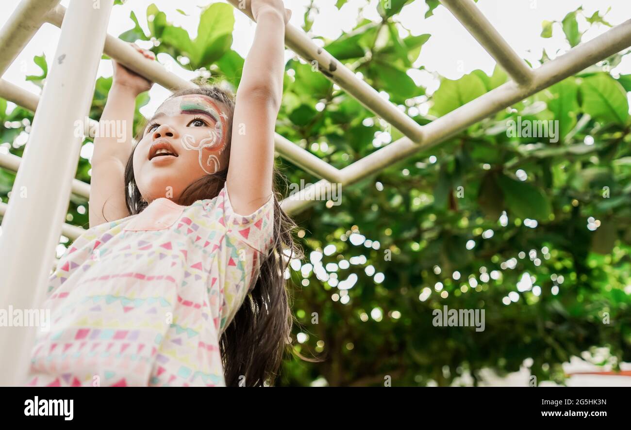 healthy girl hanging on a bar in the playground Stock Photo Alamy