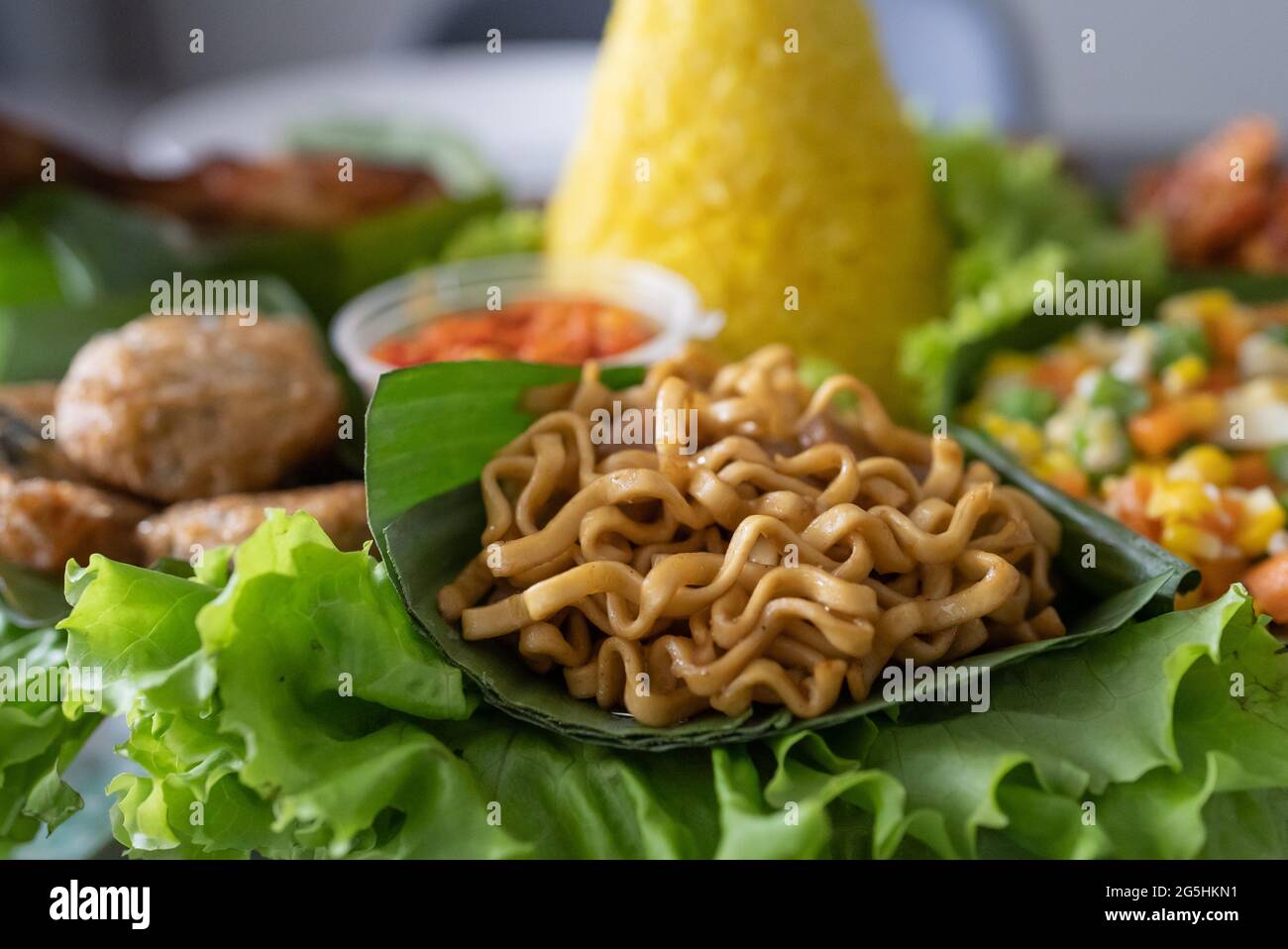 nasi tumpeng. indonesian cuisine yellow rice on banana leaf Stock Photo ...