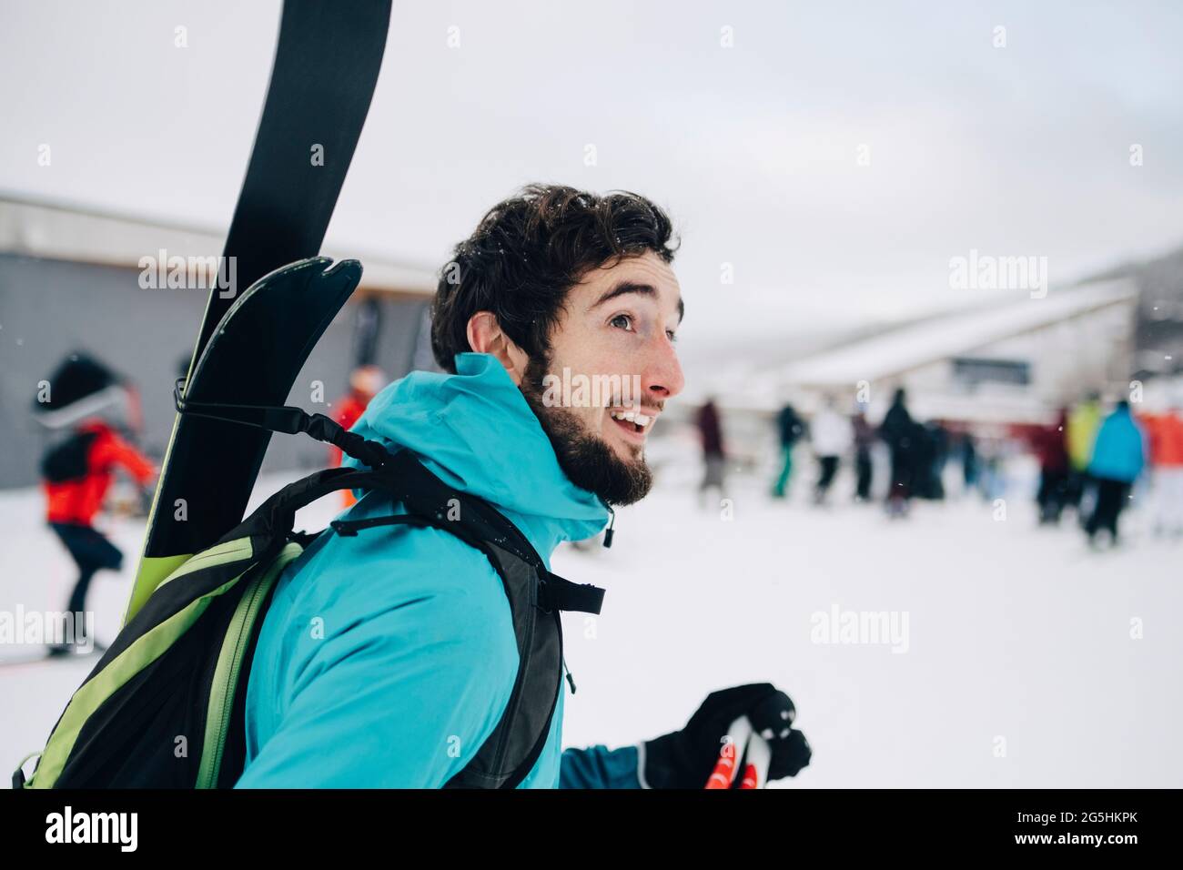 Bearded man wearing backpack while looking away at ski resort Stock Photo