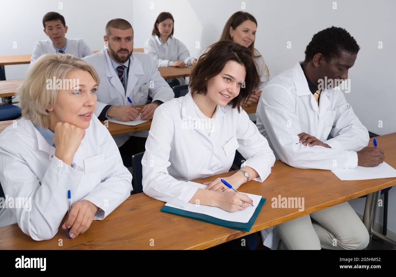 People in white coats in boardroom Stock Photo