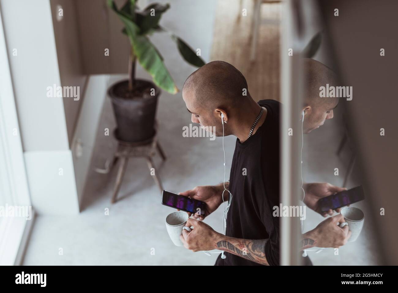 High angle view of man using smart phone while standing at home Stock Photo
