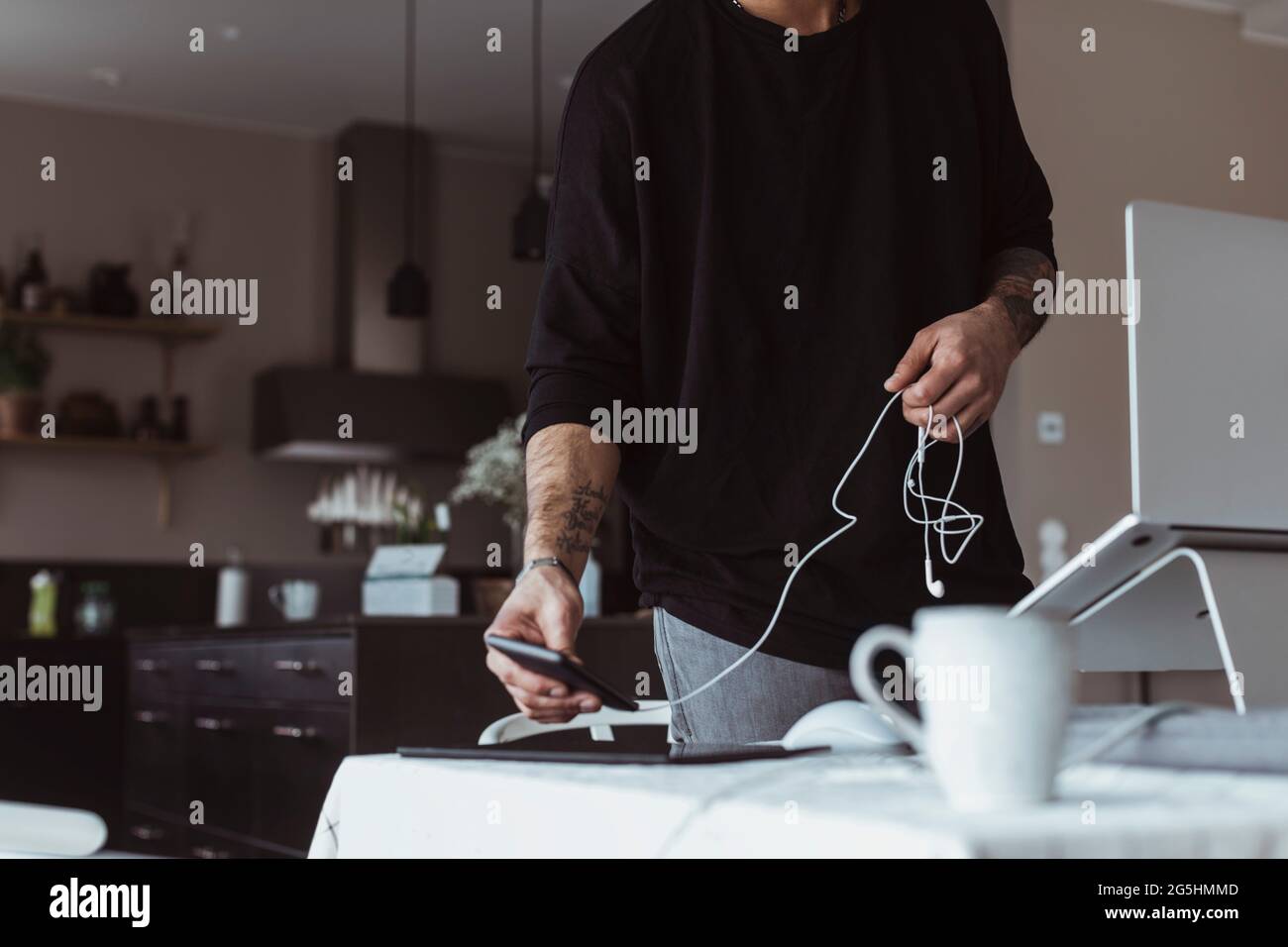 Midsection of businessman using smart phone while working at home Stock Photo