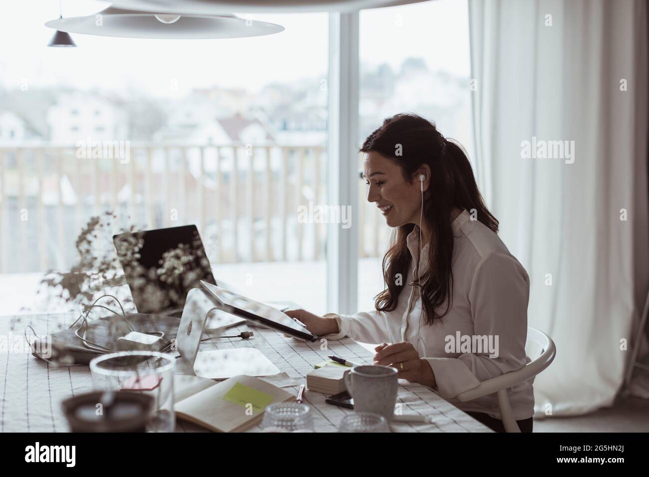 Smiling businesswoman using digital tablet at home office Stock Photo