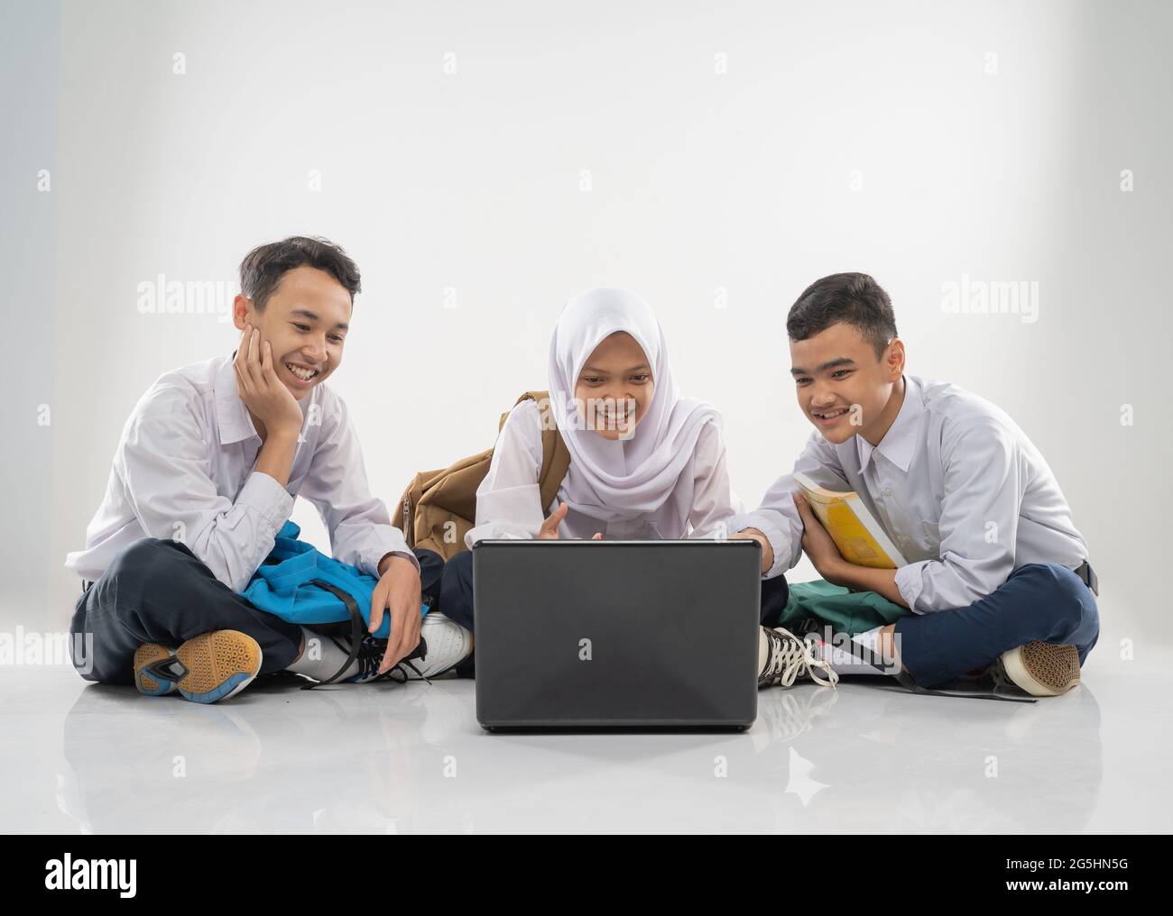 three teenagers in junior high school uniforms sitting on the floor ...