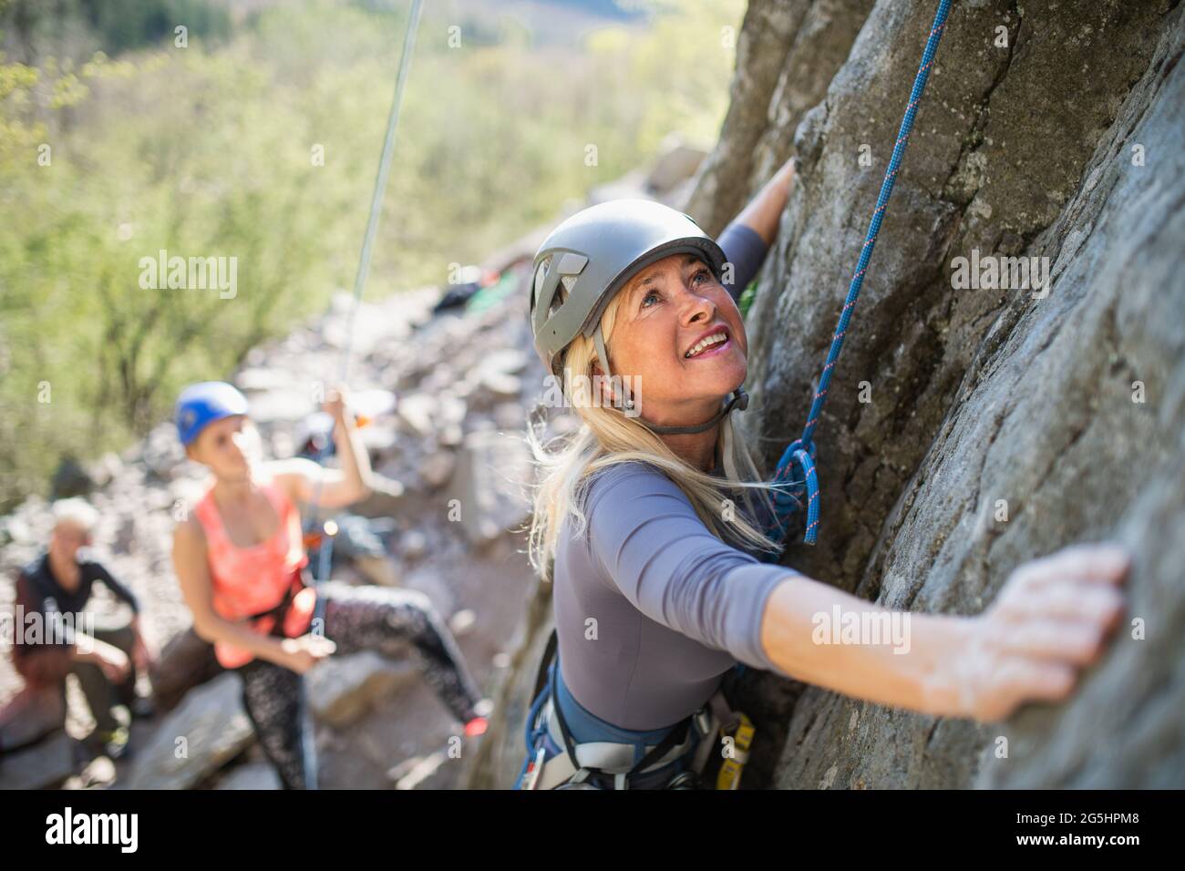Top view of group of seniors with instructor climbing rocks outdoors in ...