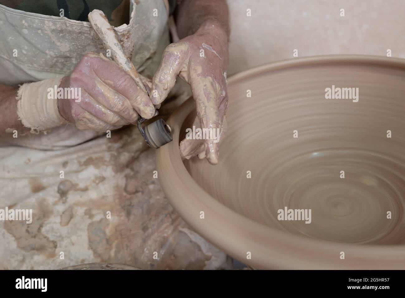 Potter working softly on pot with tools Stock Photo