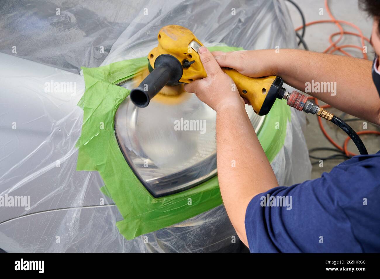 mechanic's hand is polishing the car's headlight Stock Photo Alamy