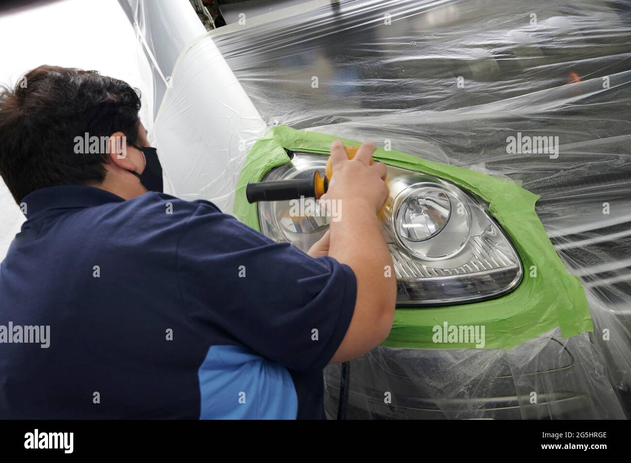 mechanic's hand is polishing the car's headlight Stock Photo Alamy