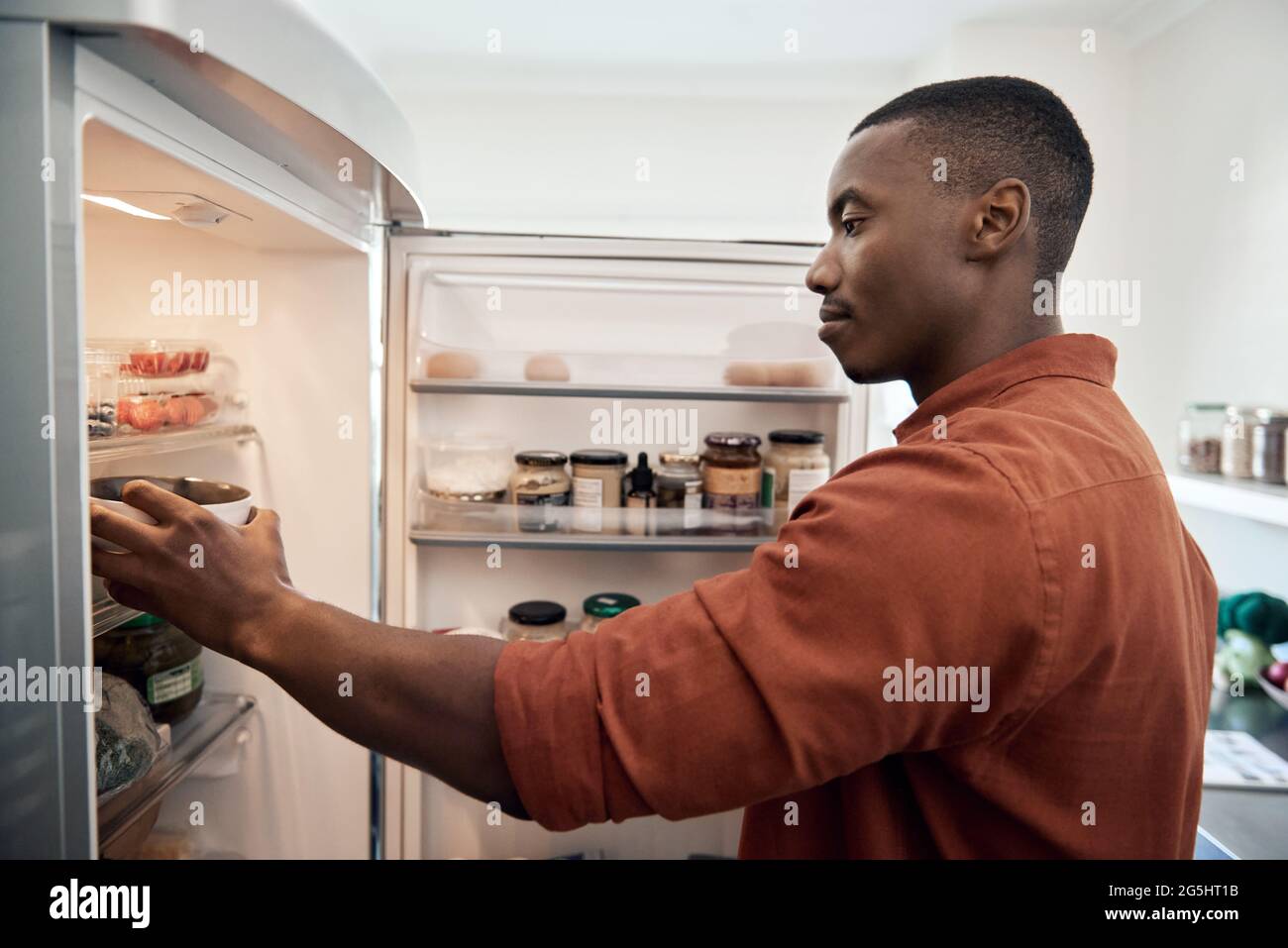 Young African man looking for something in his refrigerator Stock Photo