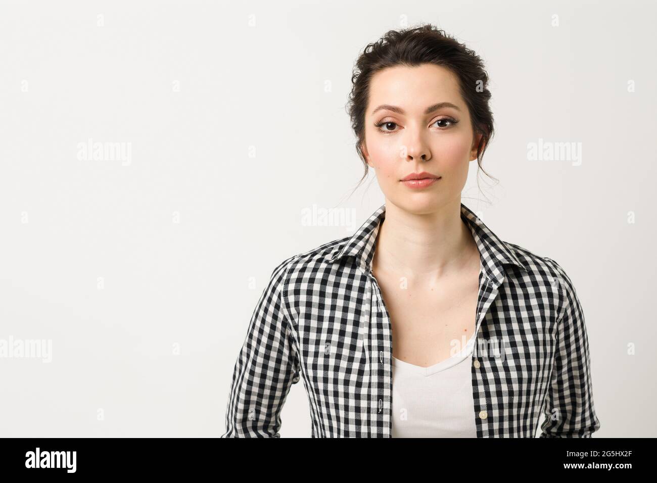 Portrait of a young woman. A charming brunette looks at the camera. Stock Photo