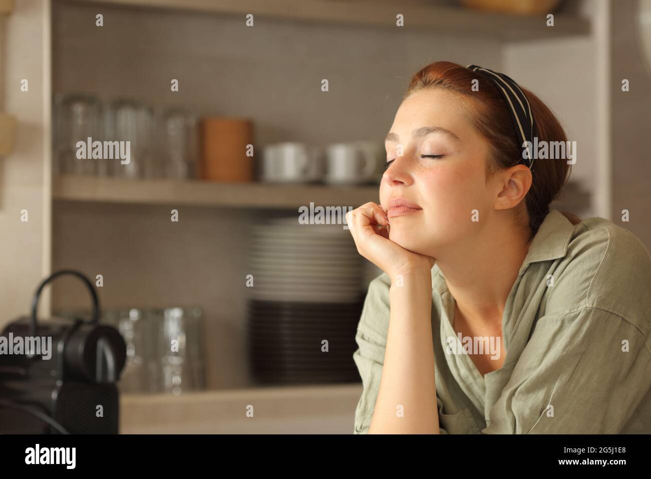 Relaxed woman resting with closed eyes in the kitchen at home Stock ...