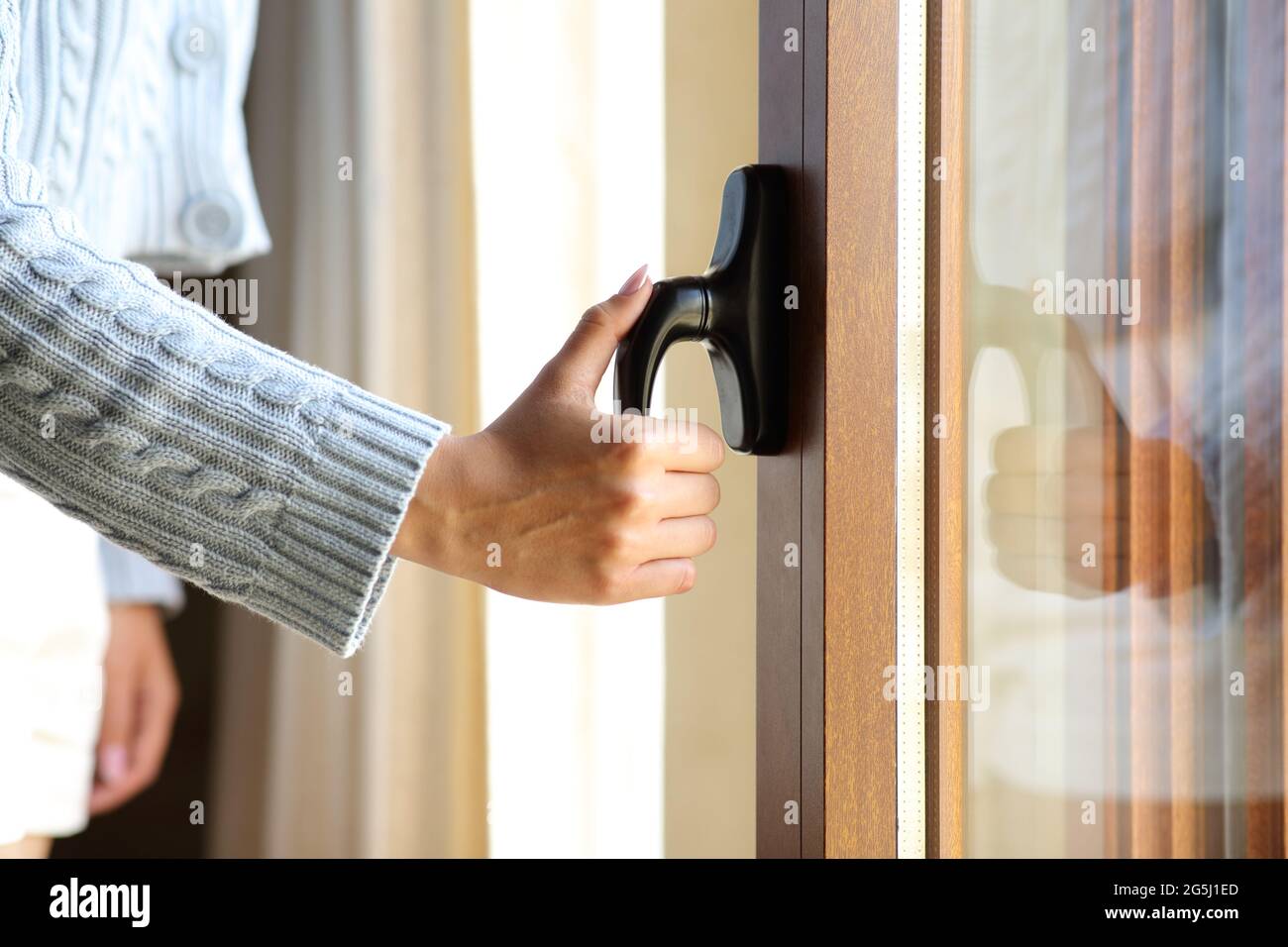 Close up of a woman hand opening a window door at home Stock Photo