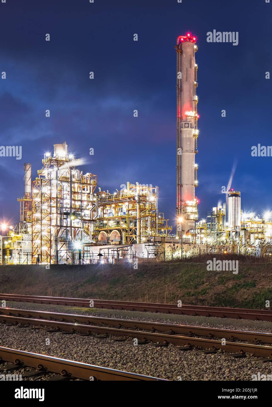 Night scene with illuminated petrochemical production plant with tracks, Port of Antwerp Stock Photo