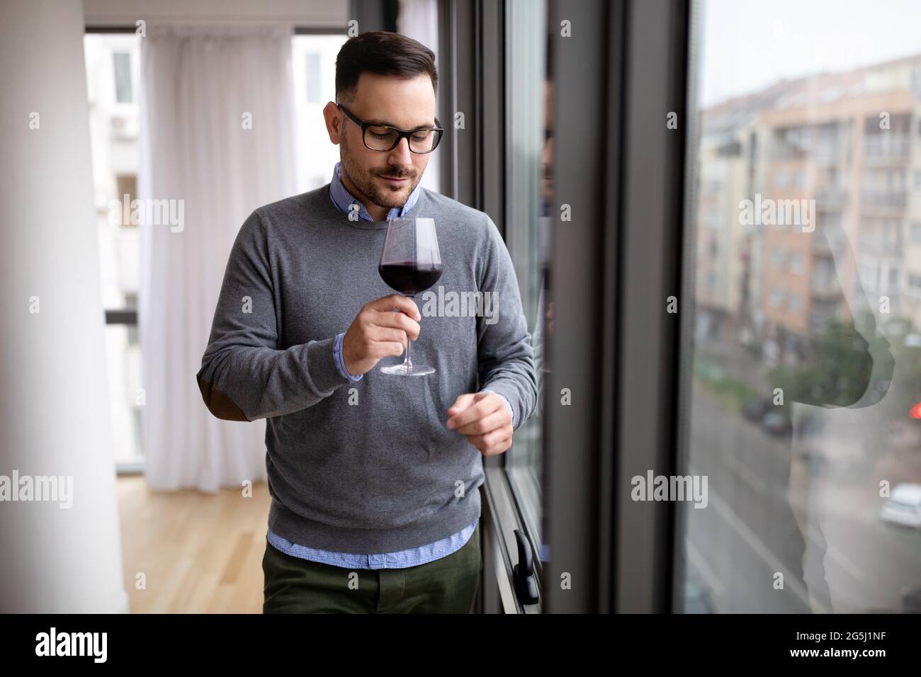 Portrait of handsome young man holding glass of red wine Stock Photo