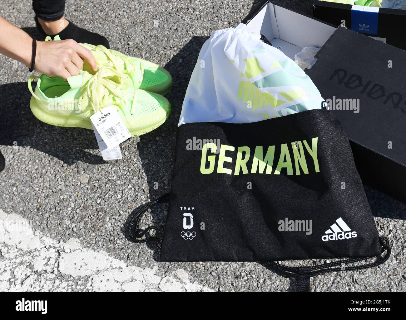 Munich, Germany. 28th June, 2021. Shoes and an adidas gym bag lie on the  floor as part of the German Olympic team gets dressed. Credit: Angelika  Warmuth/dpa/Alamy Live News Stock Photo -
