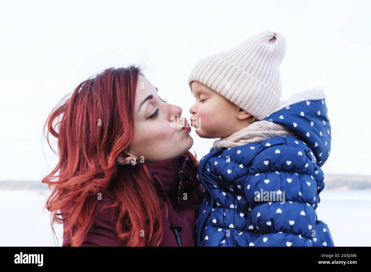 Mom kisses a little daughter - Single mom hugs a little girl - Happy mom and daughter relationship, kiss on the lips - Happy family relationship conce Stock Photo