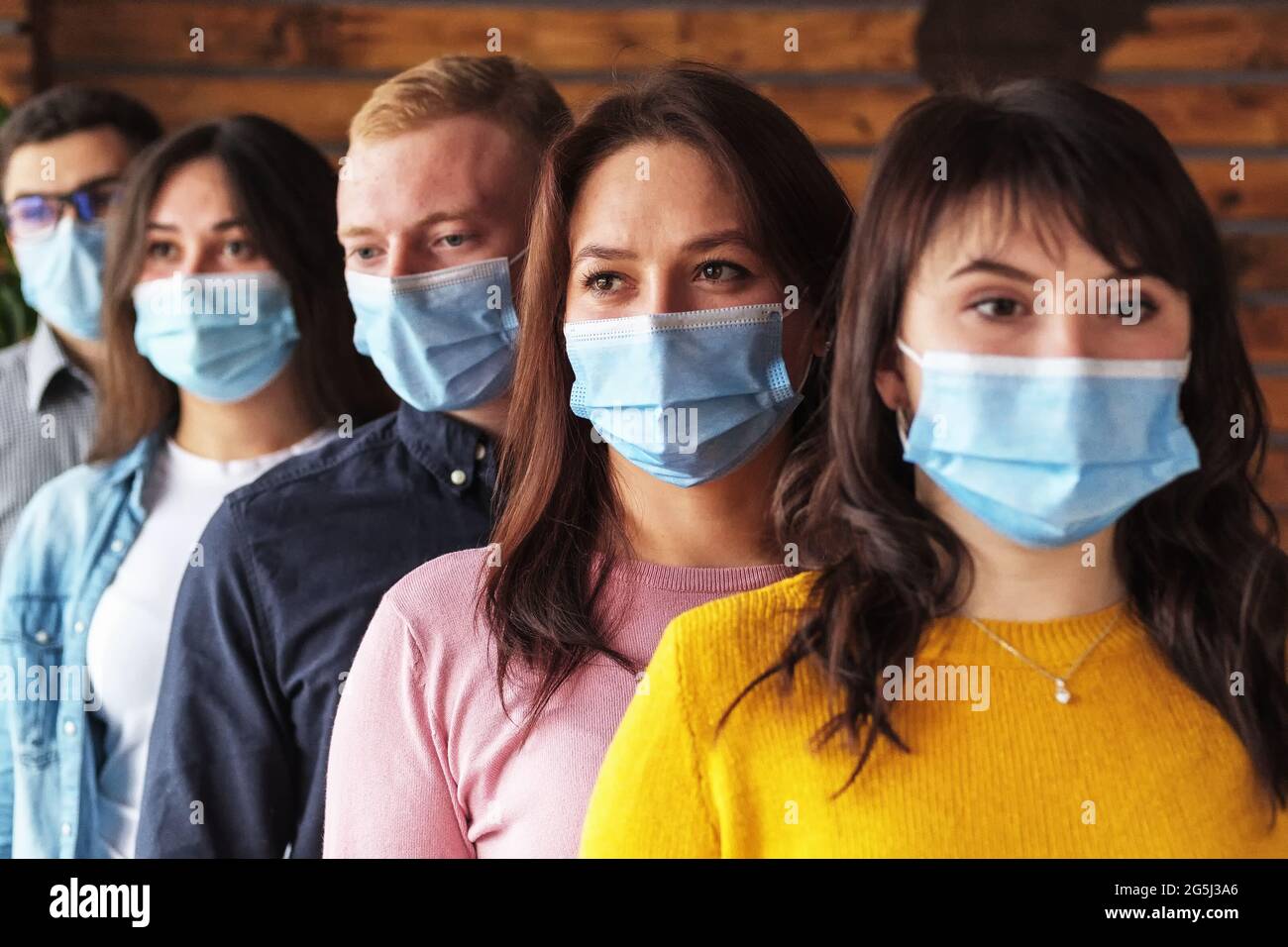 Crowd of young people wearing masks on their faces during the coronavirus pandemic - New normal masked millennials - New concept of normal life Stock Photo