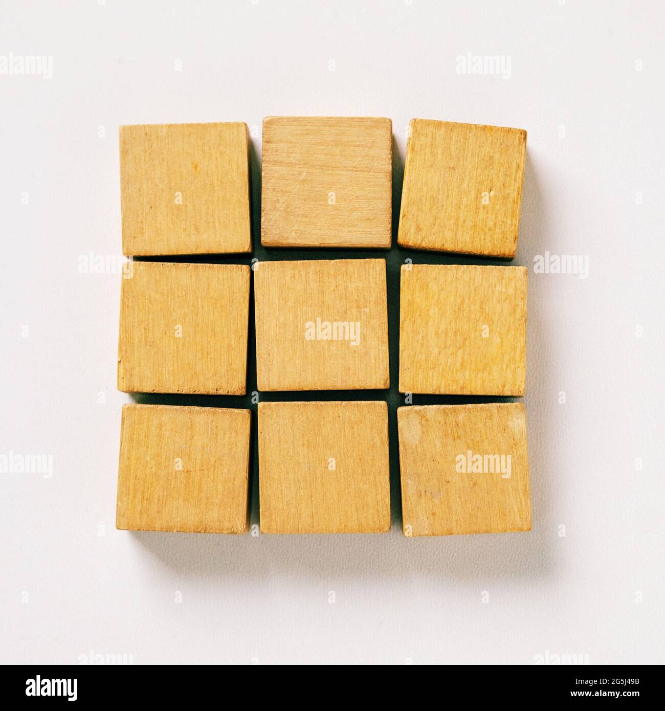 Nine wooden blocks of cubes on gray background with copy space for text - Concept of creating, building and merging Stock Photo