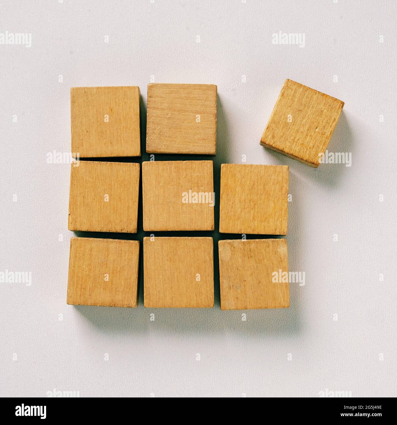 Wooden cubes are assembled into a square shape and one separates - Concept of cooperation and separation - Group and team and loneliness and differenc Stock Photo