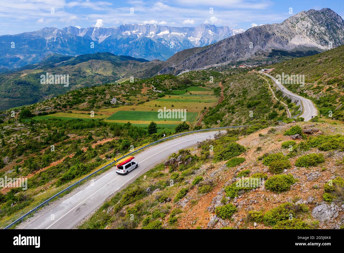 Aerial view of a windy mountain road and a car from tourists loaded ...