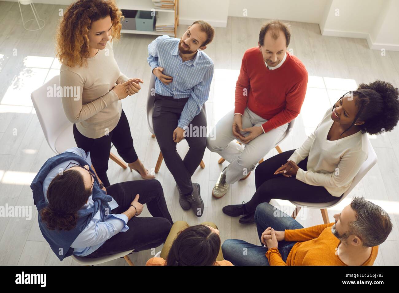 Diverse patients talking in group therapy session with professional therapist or psychologist Stock Photo