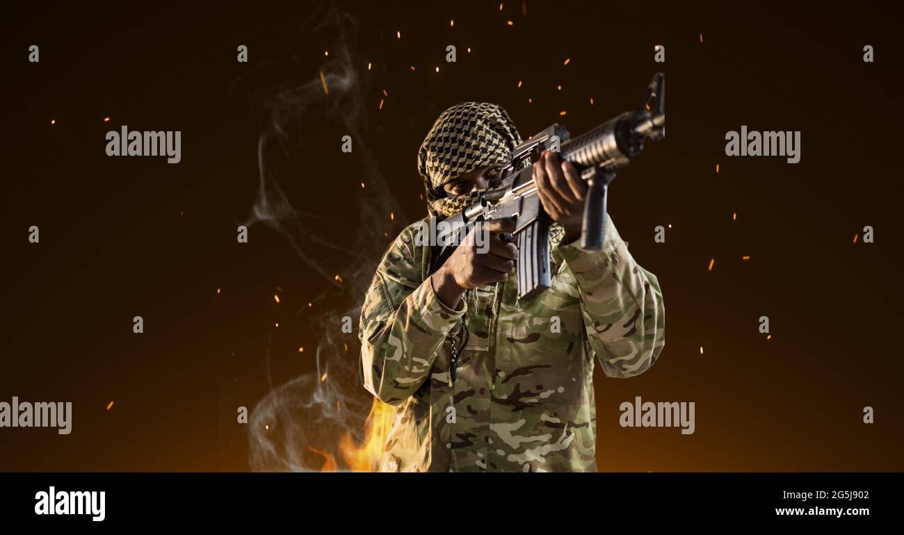 Composition of male soldier with firing gun, with smoke on dark background Stock Photo