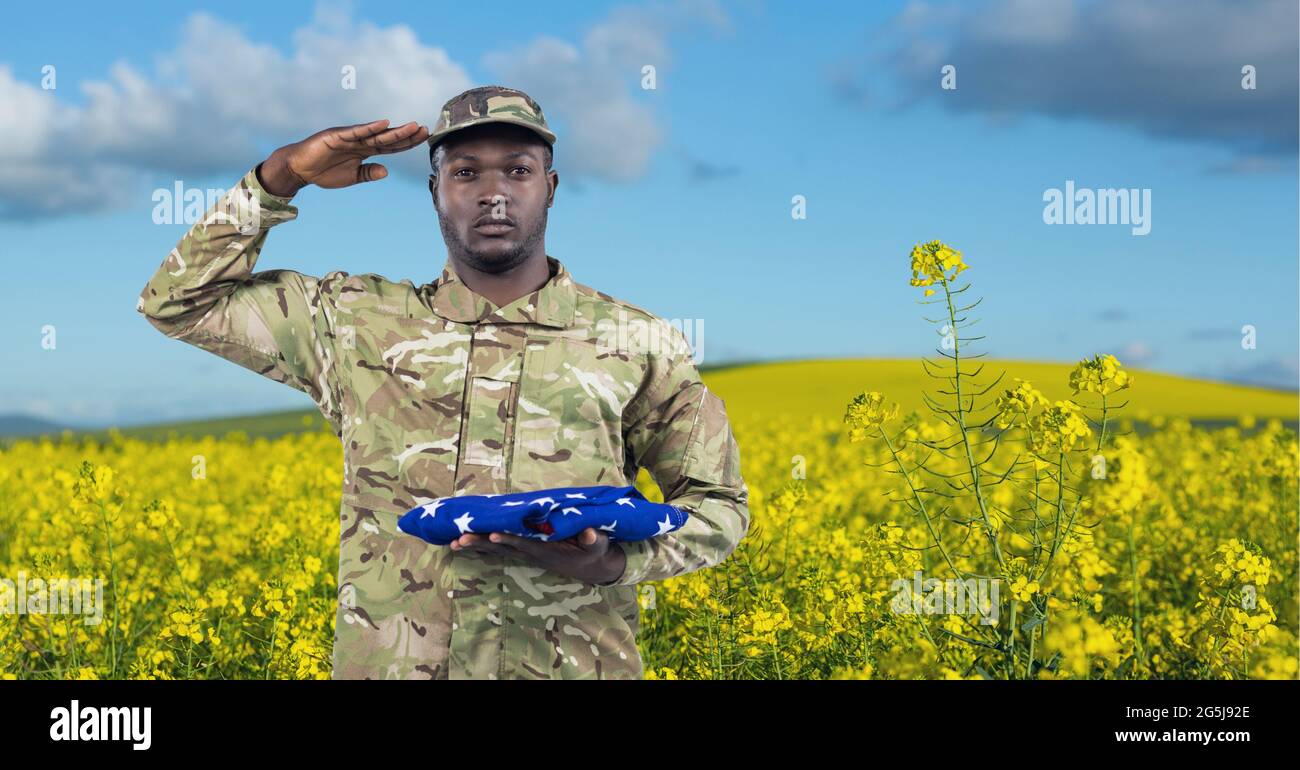 Composition of saluting male soldier with holding folded american flag ...