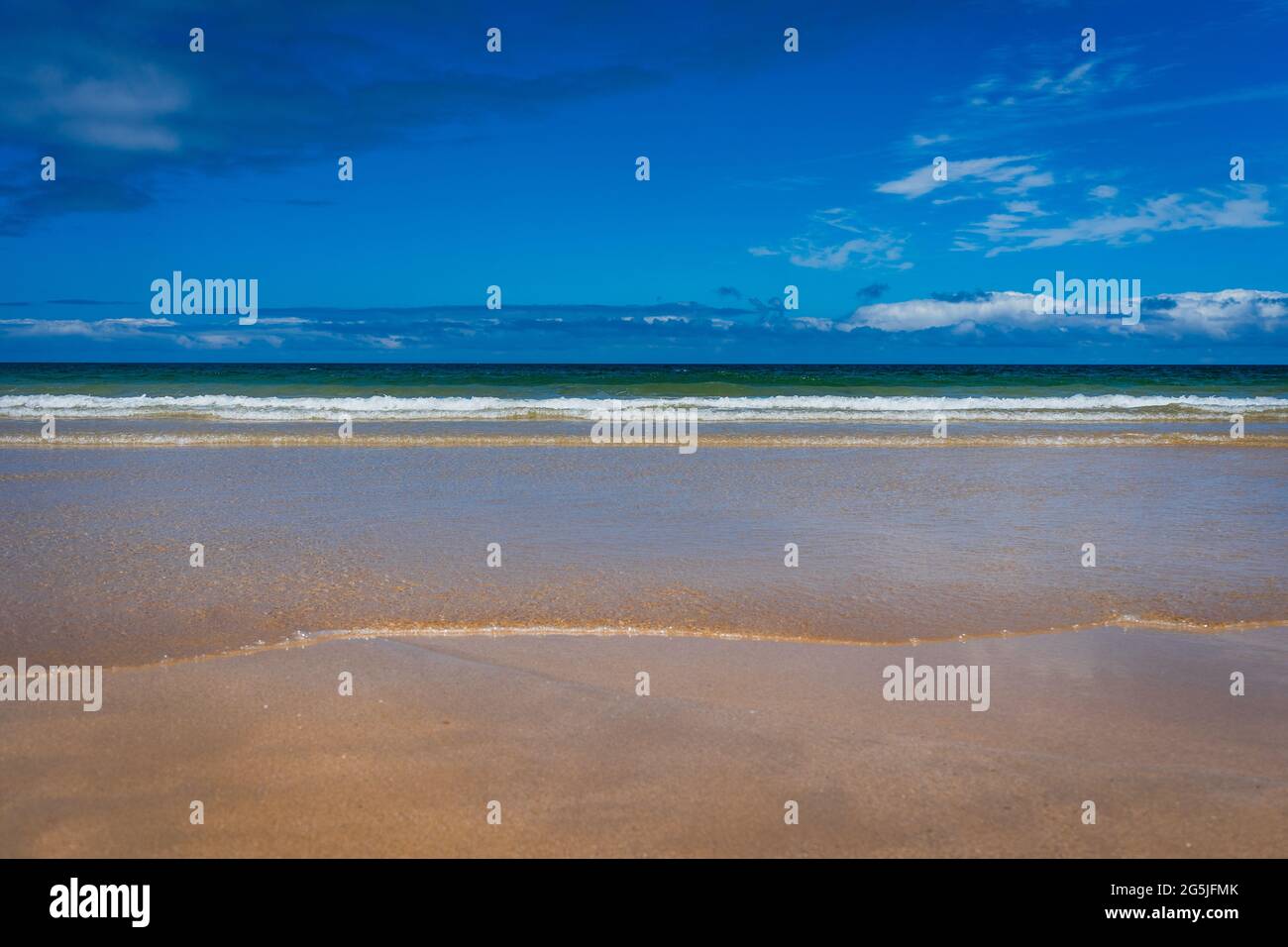beautiful beach with sea waves and blue sky Stock Photo - Alamy