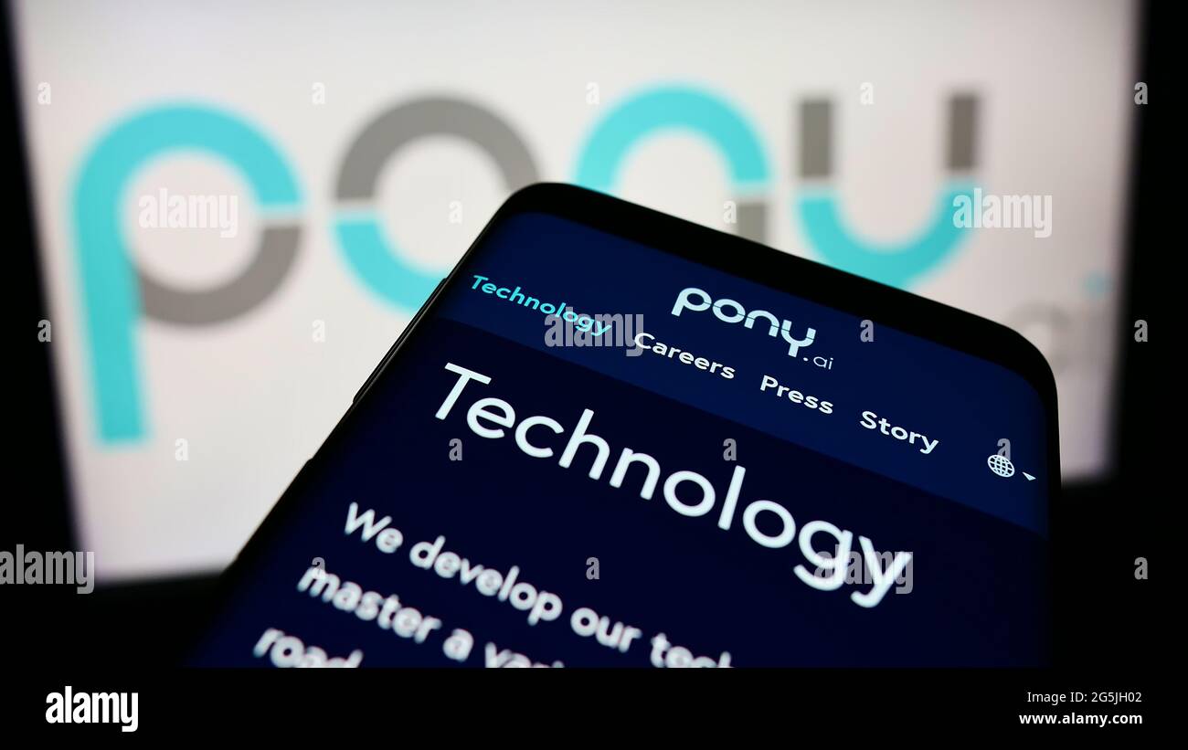 Mobile phone with webpage of autonomous vehicle company Pony.AI Inc. on screen in front of business logo. Focus on top-left of phone display. Stock Photo