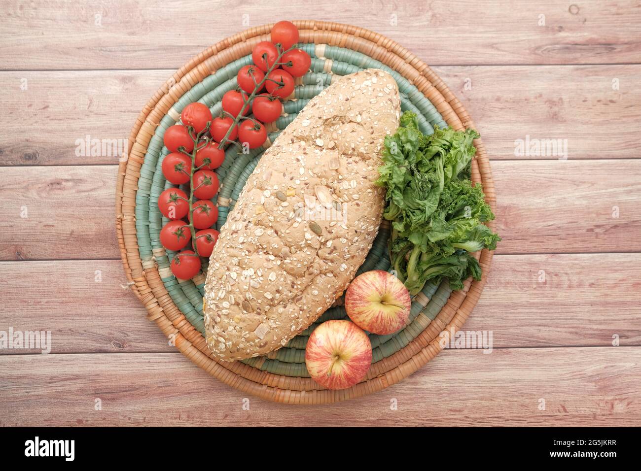 whole meal bread, apple and cherry tomato on table  Stock Photo