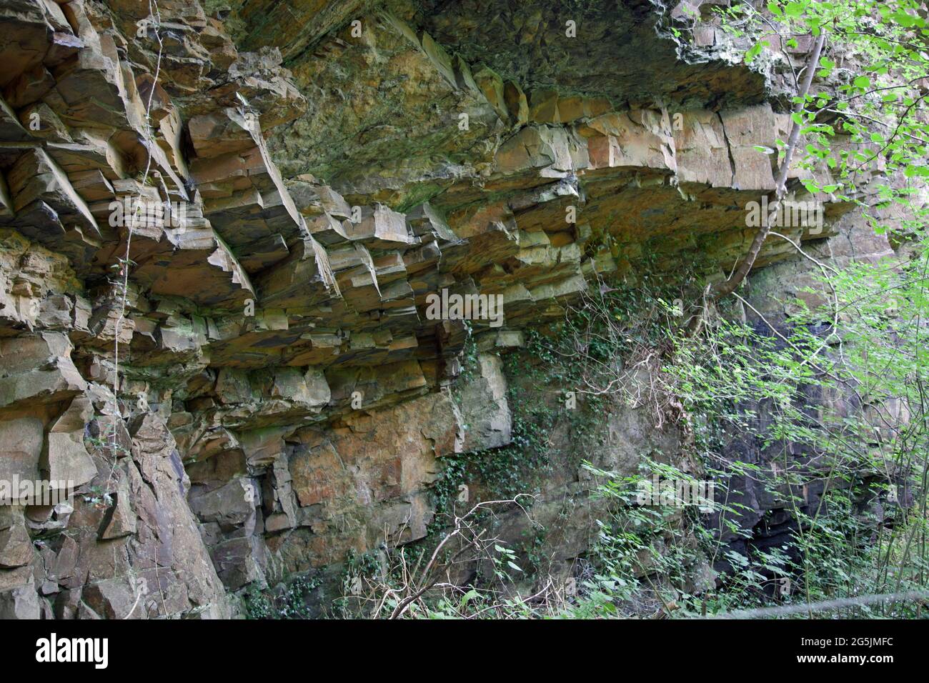 An overhang of carboniferous limestone rock, broken by weather into blocks, at Dinas Rock (Craig y Ddinas), Vale of Neath, Wales Stock Photo