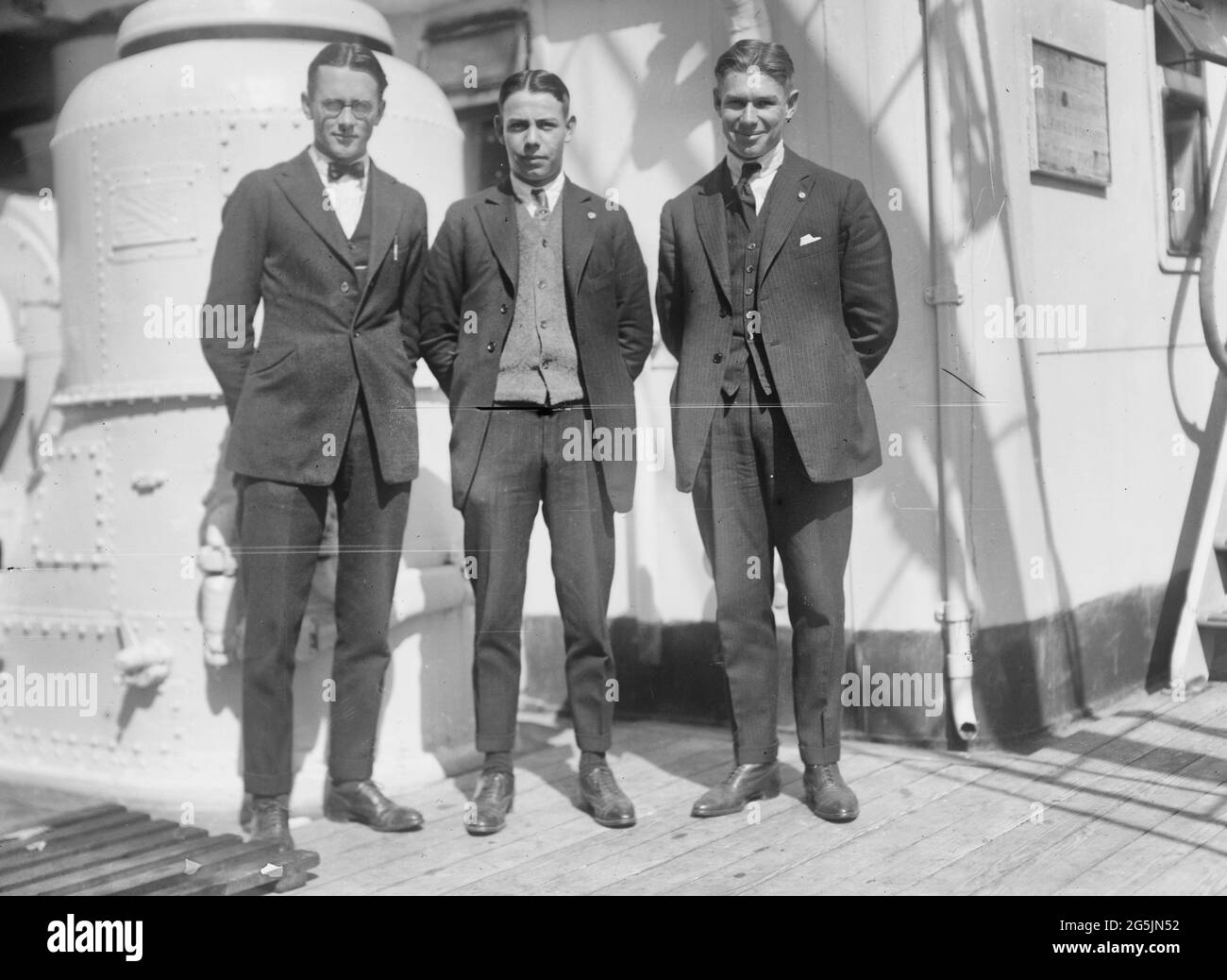Photograph shows wrestler Charles Edwin 'Charley' Ackerly (1898-1982), diver Louis Edward 'Hap' Kuehn (1901-1981), and athlete Charles 'Charley' William Paddock (1900-1943) who competed for the Americans in the 1920 Summer Olympics. They are arriving in New York City on the Aquitania on September 17, 1920. Stock Photo