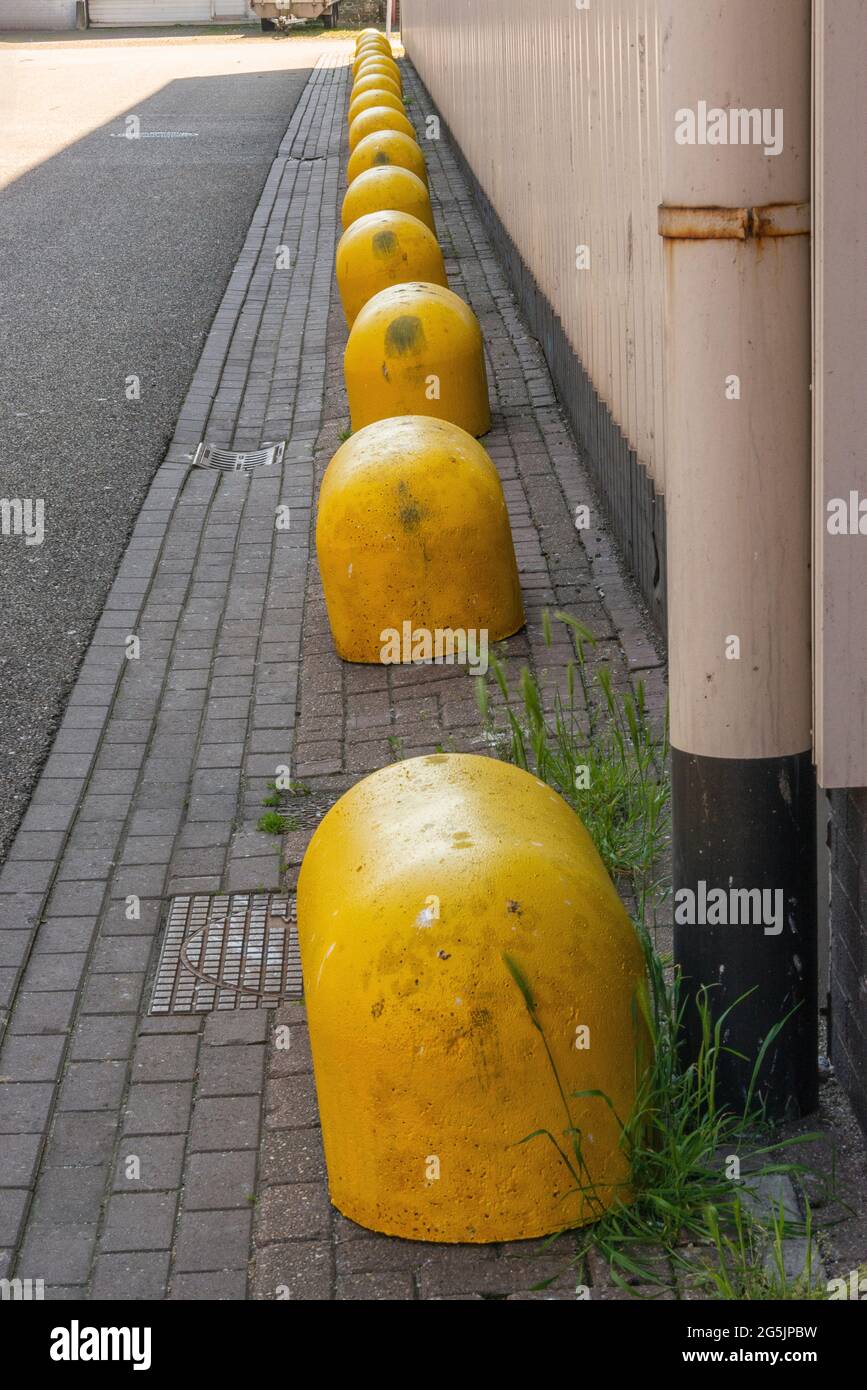 many yellow concrete blocks in a row in a street Stock Photo